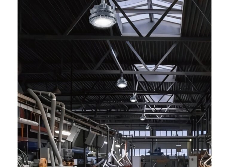 Wide warehouse aisle lit by linear LED high bay luminaires